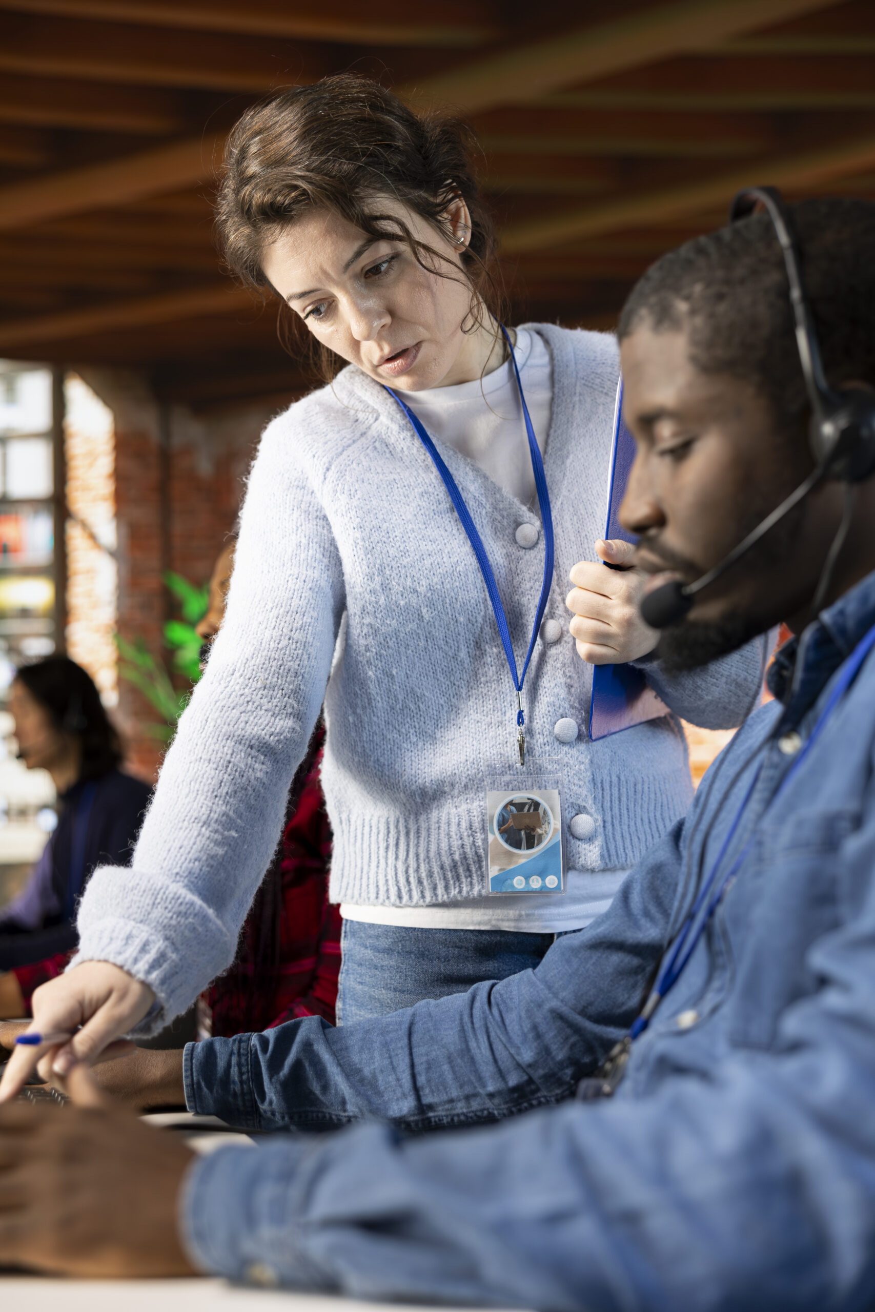 Call center manager providing guidance to intern, close up